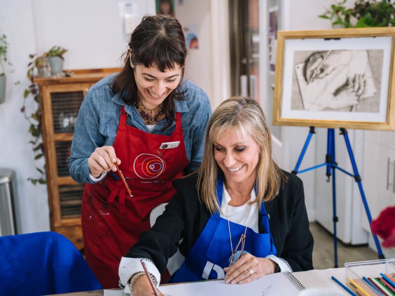 Woman smiling at art class with art teacher